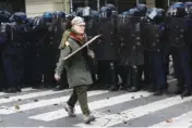  ?? AP PHOTO/AURELIEN MORISSARD ?? A protester walks by a line of riot police officers during a Tuesday protest in Paris.