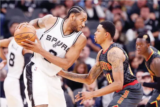  ??  ?? San Antonio Spurs forward Kawhi Leonard (2) holds the ball while defended by Atlanta Hawks small forward Kent Bazemore (24) during the first half at AT&T Center on Monday night. (USA TODAY Sports)