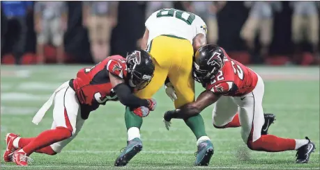  ?? John Bazemore / The Associated Press ?? Atlanta’s Brian Poole (left) and Keanu Neal (right) stop Green Bay tight end Martellus Bennett during Sunday’s NFL game at Mercedes-Benz Stadium.