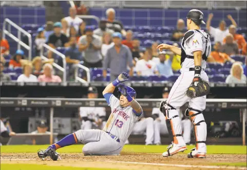  ?? Gaston De Cardenas / Associated Press ?? New York Mets’ Asdrubal Cabrera slides into home scoring on an RBI double during the eighth inning against the Marlins in Miami on Sunday. The Mets beat the Marlins 5-2.