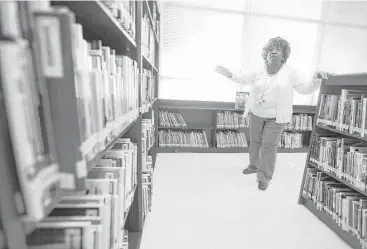  ?? Mark Mulligan / Houston Chronicle ?? Cullen Middle School librarian Janice Shaw surveys her new stocked shelves.