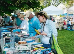  ?? DANA JENSEN/THE DAY ?? Kathleen Kenter, right, of Guilford looks at the books for sale Saturday at the 67th annual Stonington Village Fair at Wadawanuck Square in Stonington Borough.