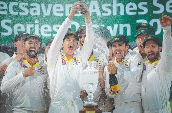  ?? Picture: AFP ?? Australia captain Tim Paine (centre) lifts the Ashes urn aloft after the fifth Test in 2019. Australia retained the trophy after the series was drawn.