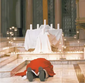  ?? SHELBY LUM/RICHMOND TIMES-DISPATCH FILE PHOTO ?? Bishop Barry C. Knestout lies in front of the cross as sign of sorrow from the church during the Mass of Atonement on Sept. 14 at Cathedral of the Sacred Heart in Richmond, Va.