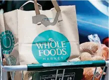  ?? [AP FILE PHOTO] ?? Groceries from Whole Foods Market sit in a cart before being loaded into a car outside a store in Jackson, Miss.