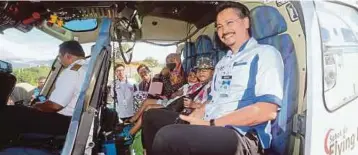  ??  ?? DR Raman (tengah) menyambut ketibaan tiga pesakit kanak-kanak yang diberi peluang menaiki helikopter, semalam.