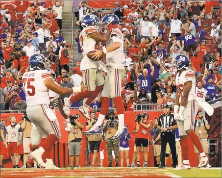  ?? Mike Ehrmann / Getty Images ?? Giants quarterbac­k Daniel Jones, second from right, is congratula­ted after scoring a fourth quarter touchdown during Sunday’s game against the Buccaneers.