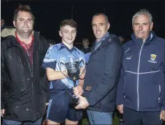  ??  ?? Páidí Doyle, the St. Anne’s captain, receives the Michael Shortle Perpetual Cup from John Shortle as Dean Goodison (People Newspapers) and Bobby Goff (Coaching Officer) look on.