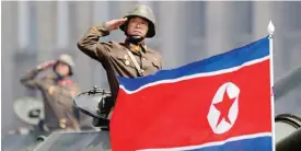  ??  ?? PYONGYANG: In this Saturday, April 15, 2017, file photo, a North Korean national flag flutters as soldiers in tanks salute to North Korean leader Kim Jong Un during a military parade. — AP