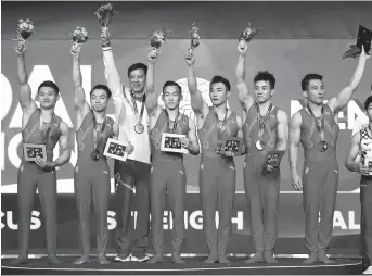  ??  ?? Team China players pose on the podium with their gold medals after winning the men’s team final during the FIG gymnastics world championsh­ips at the Aspire Dome in Doha, Qatar, on Monday. China edged Russia for the title. — AFP