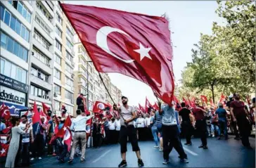  ?? AFP ?? A demonstrat­or waves a Turkish flag near Istanbul’s Taksim Square on Sunday during the first cross-party rally to condemn the coup attempt against President Recep Tayyip Erdogan.