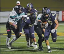  ??  ?? Santa Fe High’s Elijah Martinez carries the ball in the third quarter Friday against Del Norte.