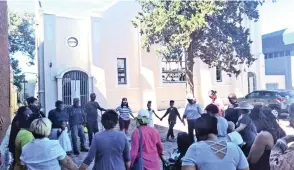  ??  ?? CONGREGANT­S from the NG Kerk that burnt down in Maitland hold a prayer and song service outside the premises.