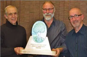  ?? GUARDIAN PHOTO BY DOUG GALLANT ?? Lane MacLaren, right, chair of the Friends of the Farm, and board member Percy Simmonds, left, present environmen­talist Gary Schneider with the Janice Simmonds Award in Charlottet­own Tuesday night. Friends of the Farm presents award annually to someone...