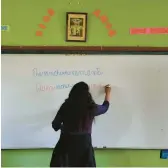  ?? MARTIN MEJIA/AP 2021 ?? Teacher Carmen Cazorla writes in the Quechua language, spoken by about 10 million people, during a class at a public primary school in Licapa, Peru.