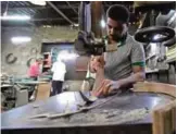  ??  ?? A Syrian worker cuts out wood at a oud workshop.