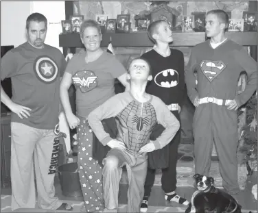  ?? Amy Wilson/AP ?? Superhero: This photo provided by Amy Wilson shows her children posing for a photo in matching holiday pajamas in her home in Marietta, Ga. For many families, dressing up in matching pajamas is a Christmas Eve and Christmas morning tradition — even when the kids get older.