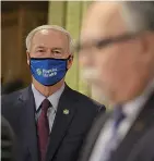  ?? Arkansas Democrat-Gazette/Staton Breidentha­l ?? ■ Gov. Asa Hutchinson, left, wears a mask Thursday at the state Capitol in Little Rock as he listens to Dr. Jose Romero during the daily COVID-19 briefing. Hutchinson announced a statewide mask order at the briefing.