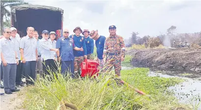  ?? — Gambar UKAS ?? PANTAU SITUASI: Uggah (depan, tiga kiri) bersama wakil-wakil agensi kerajaan ketika melawat lokasi kebakaran tanah gambut di Kuala Baram, semalam.