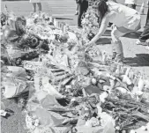  ?? ROBERT HANASHIRO, USA TODAY ?? Jeanne Belez of Marysville, Ore., places a bouquet of flowers at a memorial that popped up along Las Vegas Boulevard near the Mandalay Bay hotel.
