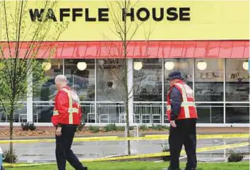  ?? AP ?? Emergency workers walk outside the Waffle House restaurant in Nashville, Tennessee, where four people died after a gunman opened fire early on Sunday.