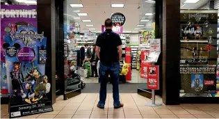  ??  ?? A 27-year-old selfdescri­bed tech addict poses for a portrait in front of a video game store at a mall in Everett, Washington. He asked to remain anonymous because he works in the tech industry.