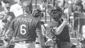  ?? AP ?? Home plate umpire Jim Wolf tells Dodgers' David Peralta to take a base after a pitching clock violation.