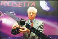  ?? Matthew Fearn / Associated Press ?? European Space Agency Director of Science Roger Bonnet holds a model of the Rosetta spacecraft, which is being prepared for a mission to the Comet Wirtanen.