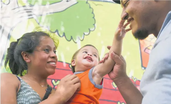  ?? Photo / AP ?? Adalicia Montecinos and Rolando Bueso Castillo are reunited with their 15-month-old son, Johan.