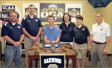  ??  ?? Among those at Oakwood Christian Academy last week to witness Matthew McDonough (seated, center) sign his letter of intent to play basketball at Truett-McConnell University were OCA assistant coach Scott McSpadden, OCA head coach and father Wayne...