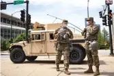  ?? ASHLEE REZIN GARCIA/SUN-TIMES ?? Members of the Illinois National Guard keep watch and direct traffic near East 24th Place and South King Drive on Wednesday.