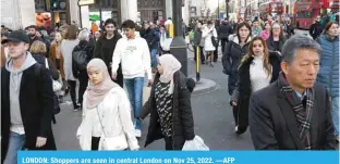  ?? —AFP ?? LONDON: Shoppers are seen in central London on Nov 25, 2022.