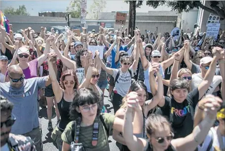  ?? Robert Gauthier Los Angeles Times ?? DEMONSTRAT­ORS HOLD hands during a rally in Venice to celebrate diversity and unity, one of many held around the country.