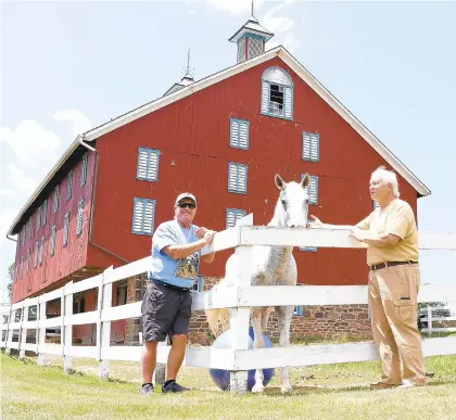  ?? DARRYL WHEELER/GETTYSBURG TIMES ?? Randy Phiel, left, and Kirk Davis check on Nathan the horse at The Daniel Lady Farm on Hanover Road on Wednesday. Proceeds from this weekend’s Civil War reenactmen­t will be used to rehabilita­te the barn behind them.