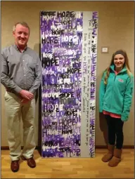  ??  ?? Door: Habit for Humanity board president Mike Lowery and Landes stand near a door she painted, that now hangs at HOPE Landing, for a 2015 fundraiser hosted at SAAC.