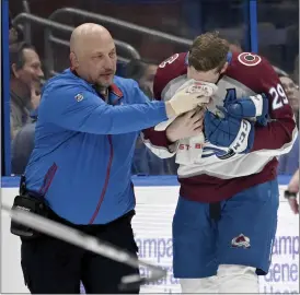  ?? JASON BEHNKEN — THE ASSOCIATED PRESS ?? Avalanche center Nathan Mackinnon is helped off the ice after being hit with the puck during the second period of Thursday’s game against the Lightning in Tampa, Fla.