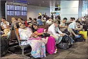  ?? AP/HADI MIZBAN ?? Stranded travelers sit and wait Tuesday at Hamad Internatio­nal Airport in Doha, Qatar. Flights were canceled after Qatar’s Persian Gulf neighbors and other Arab countries cut diplomatic ties.