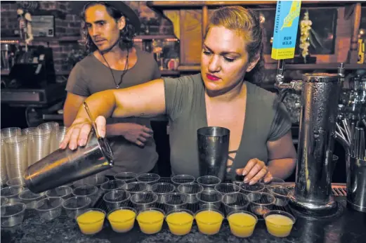  ?? SASHA CHAROENSUB/LISTEN BAR ?? Bartender Matthew Bray (left) looks on while Crystal Chasse prepares mocktails at New York’s Listen Bar, which serves no alcohol.