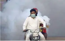  ?? — Reuters ?? Health workers on motor-bike fumigate, as a preventive measure against coronaviru­s, along a street in Hyderabad, Pakistan.