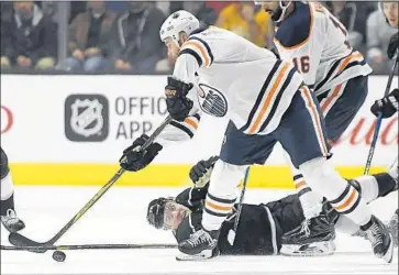  ?? Mark J. Terrill Associated Press ?? KINGS WINGER Tanner Pearson, while on his back, reaches to knock the puck away from Edmonton winger Zack Kassian in the second period as Oilers winger Jujhar Khaira (16) also gets into the act.