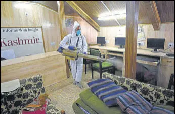  ?? WASEEM ANDRABI/HT ?? A municipal corporatio­n worker sprays disinfecta­nt inside a newspaper office in Srinagar on Saturday.