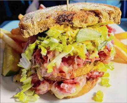  ?? Photos by Susie Davidson Powell / For the Times Union ?? The corned beef sandwich at the new Albany War Room Tavern is served in the style of a club sandwich and named after Grover Cleveland, who was governor of New York before becoming U.S. president.