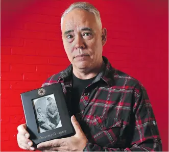  ?? GAVIN YOUNG ?? Tim Tamashiro poses with a photograph of his grandfathe­r, Private Masuro Tamashiro, who volunteere­d with 221 other Japanese-Canadians to fight in the First World War.