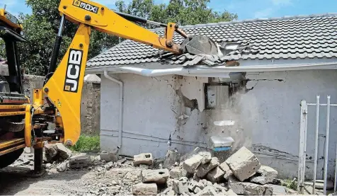  ?? Pictures: UVIWE JARA ?? DEMOLITION: An Enoch Mgijima Local Municipali­ty TLB demolishes illegally built flats in Toptown.