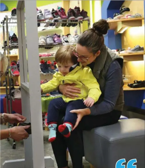  ?? Pic: Carl Brennan ?? Linda Foley fitting a child for his first pair of shoes when retail reopened last June following the country’s exit from the first lockdown.