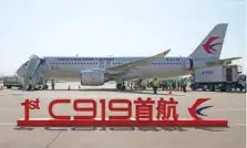  ?? DING TING/XINHUA VIA AP ?? A sign reading “1st C919 inaugural flight” is shown May 28 in front of a Chinese-made passenger aircraft as it prepares for its first commercial flight from Shanghai.