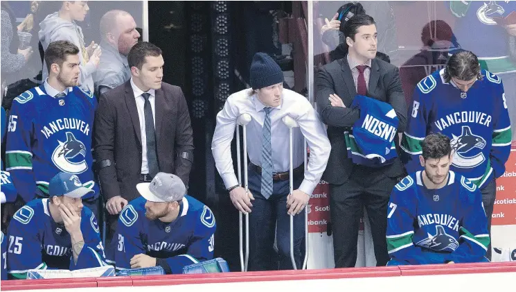  ?? — THE CANADIAN PRESS ?? Vancouver Canucks right wing Brock Boeser, centre, took a shot off his left foot in the second period of Sunday’s game against Calgary and did not return.