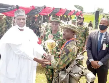  ?? PHOTO: Hassan Ibrahim ?? Bauchi State Deputy Governor, Senator Baba Tela, presenting trophy to the Army Headquarte­rs Garrison Abuja which emerged 1st position during the 2021 Inter-Formation Platoon Officers’ Crossing Competitio­n of the Nigerian Army in Bauchi yesterday