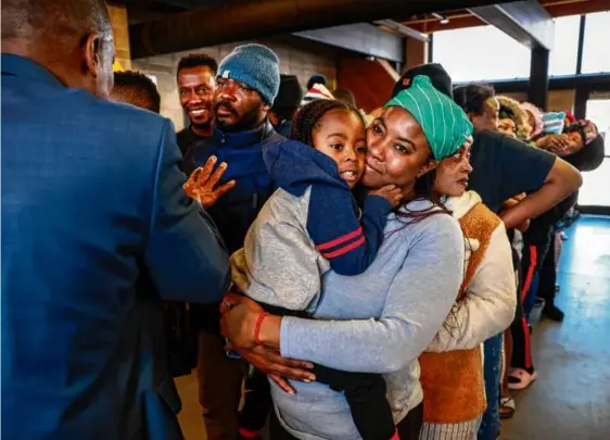  ?? ?? Mireille Pierre comforted her son Marventz, 3, while Dieufort Fleurissai­nt, a.k.a. “Pastor Keke,” spoke to a group of Haitians.