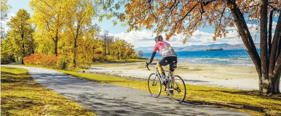  ?? LOCAL MOTION VIA THE ASSOCIATED PRESS ?? A man cycles along the Island Line Rail Trail in Burlington, Vt. Viewing fall foliage while enjoying one of New England’s many scenic trails is a fun and healthy way to experience autumn.